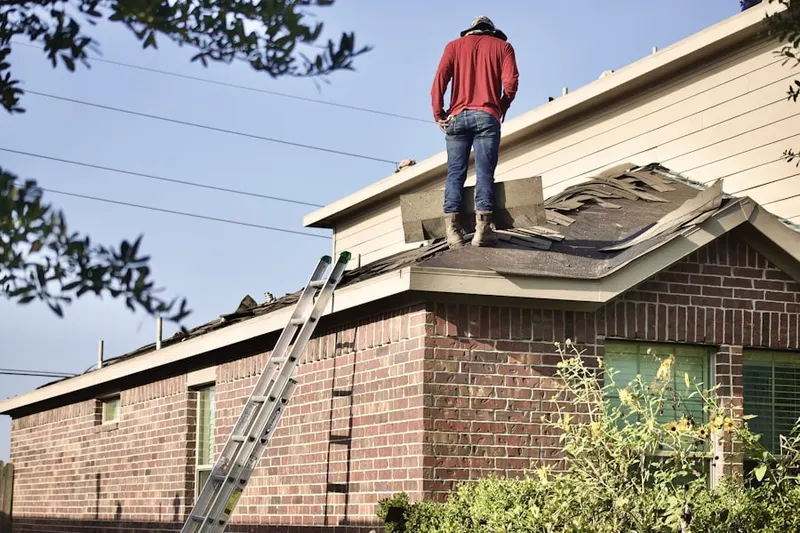 Professional roofer working on a residential roof in Sippewisset